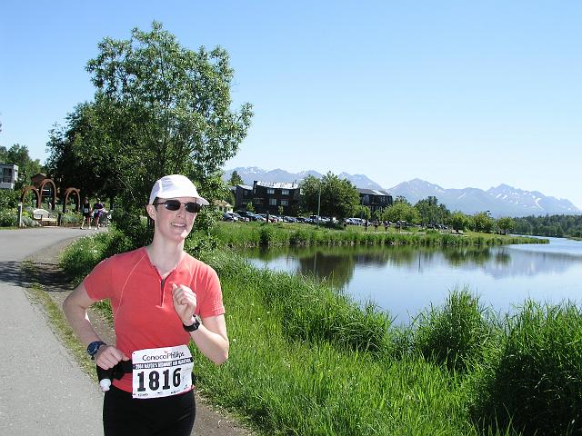 P6190036.JPG - Joyce about one mile from the finish of her first marathon, the Mayor's Midnight Sun Marathon. The course was beautiful, with about one-half of it on dirt trail. She was hurting quite a bit at this point, but was able to smile for the camera!